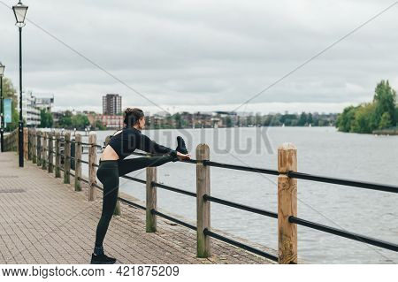 Beautiful Young Slim Woman Is Smiling And Stretching After Running. Stay Healthy, Do Sport Outside. 
