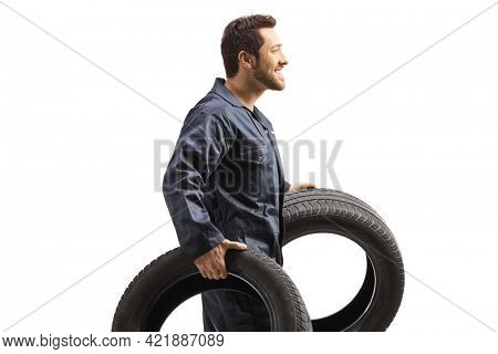 Aauto mechanic worker carrying big tires isolated on white background