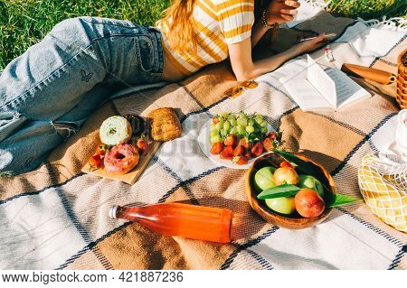 Fresh Fruits And Berries, Drinks And Bakery On Picnic Blanket Outdoor, Summer Vacation, Woman Lying 