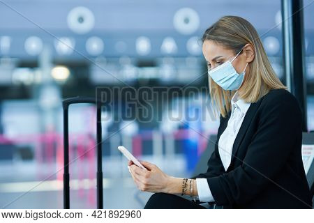 Adult female passenger using smartphone at the airport