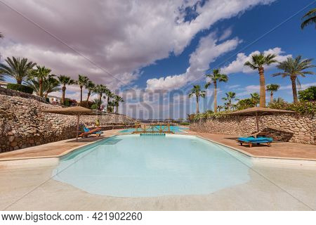 Man jums into the swimming pool in african camping
