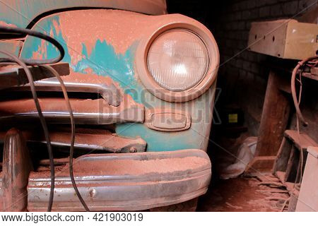 1950s Car Headlights. Old Retro Car Stands In The Garage Covered With Dust. High Quality Photo