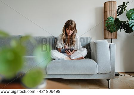 Woman in pyjamas working at home during coronavirus outbreak