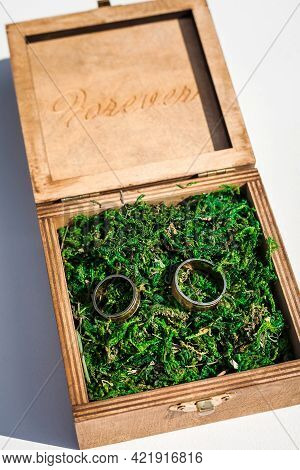Wedding Rings In A Wooden Box Filled With Moss