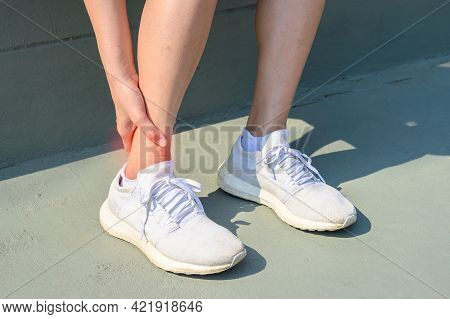 Cropped Shot Of Woman Runner Suffering From Ankle Pain. Ankle Pain May Be Caused By An Injury, Like 