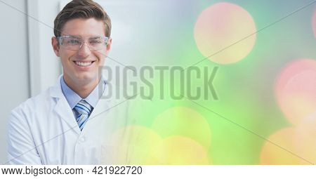 Composition of smiling male doctor, with colourful blurred copy space to right. medical and science research concept digitally generated image.