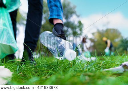 Hand Of Man Picking Up Bottle Into Garbage Bags While Cleaning Area In Park. Volunteering, Charity, 