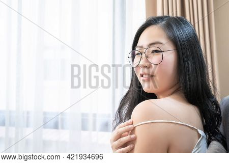 Asian Woman Is Posing With Her Sexy Shoulder On Her Bed In The Bedroom.