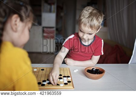Brother And Sister Playing Chinese Chess Go At Home, Sibling Have Fun Together With Igo Go Stones, W