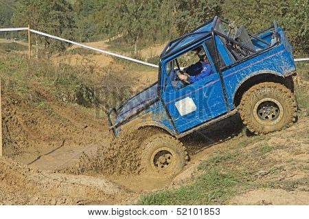 Blue Car Is Entering  Into A  A Puddle Of Mud