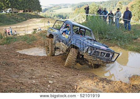 Black Car Is Passing Through  A Puddle Of Mud