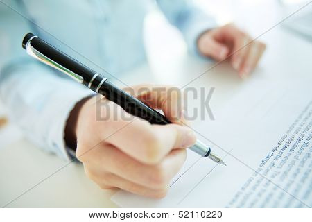 Close-up image of a business woman going to put her signature