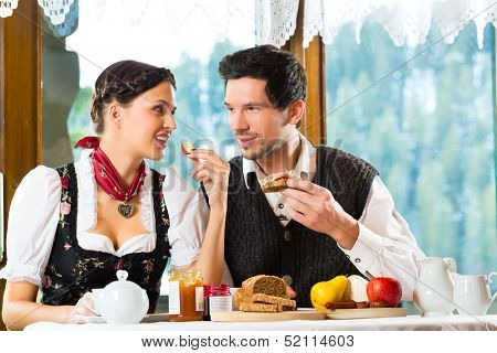 Couple in a traditional mountain hut having a hearty breakfast