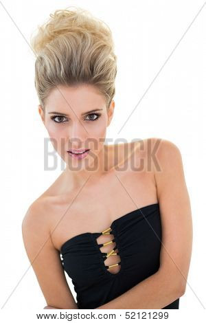 Focused stern blonde model looking at camera on white background