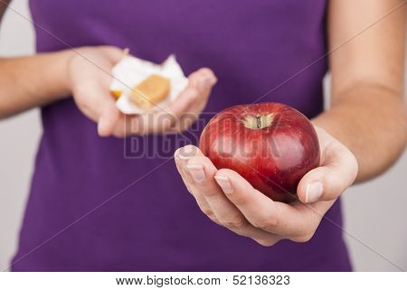 Young woman preffering candy instead of fruit