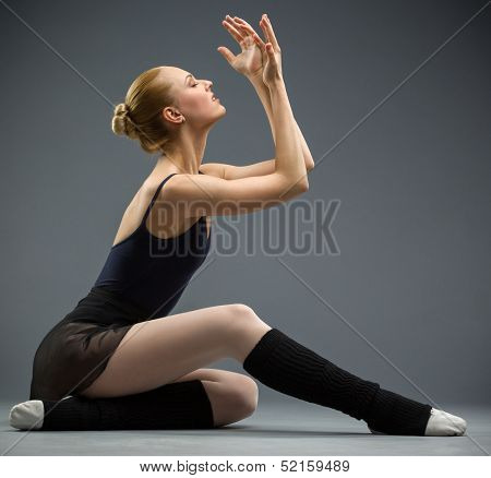 Dancing on the floor ballerina with hands up, isolated on grey. Concept of elegant art and sportive hobby