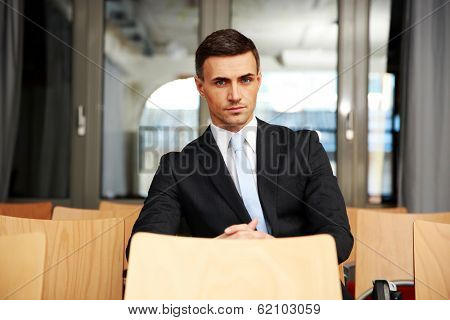Confident businessman sitting at conference hall
