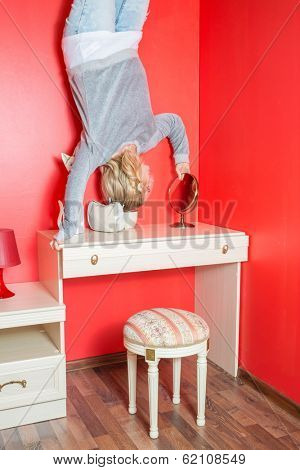 Girl upside down in the bedroom above the dressing table