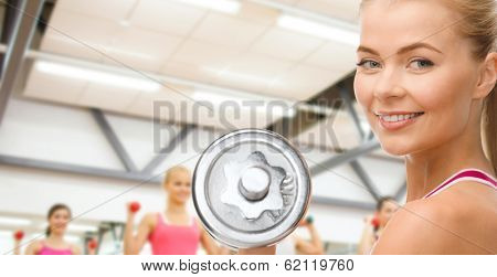 fintess, healthcare and dieting concept - young sporty woman with heavy steel dumbbell