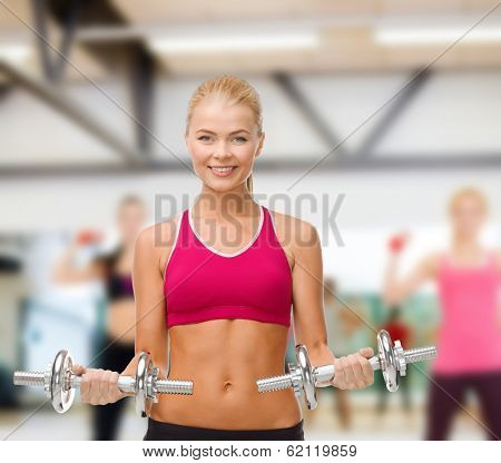 fitness, healthcare and dieting concpt - young sporty woman with heavy steel dumbbells