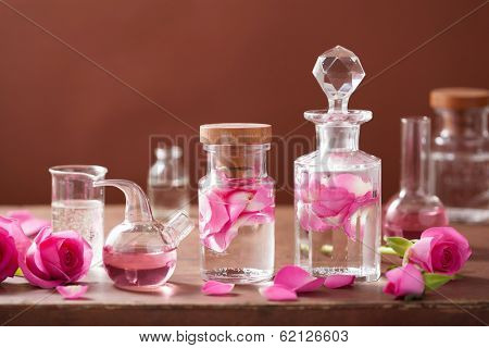 alchemy and aromatherapy set with rose flowers and flasks