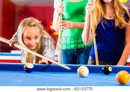 Family playing together billiard. Brother kick off with queue and balls on pool table 
