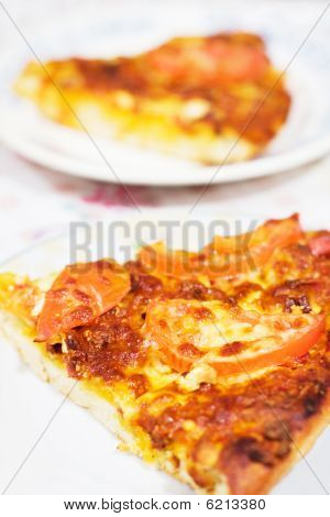 Una fetta di pizza con pomodoro e formaggio sulla piastra