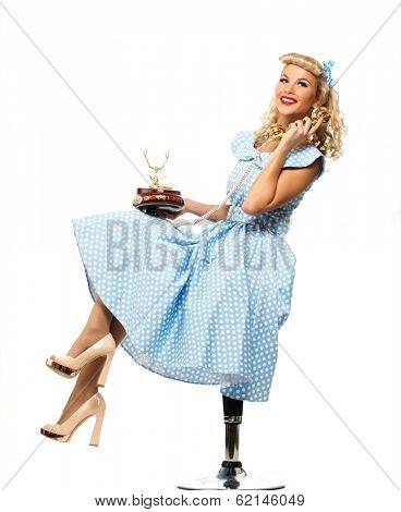 Coquette blond pin up style young woman in blue dress with vintage phone 