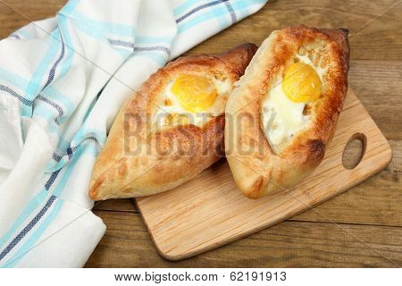 Ajarian khachapuri on wooden table close up