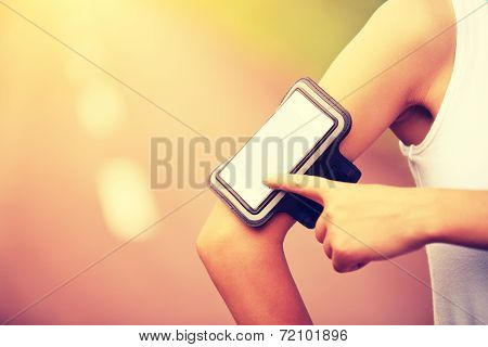 Runner athlete listening to music from smart phone mp3 player smart phone armband.