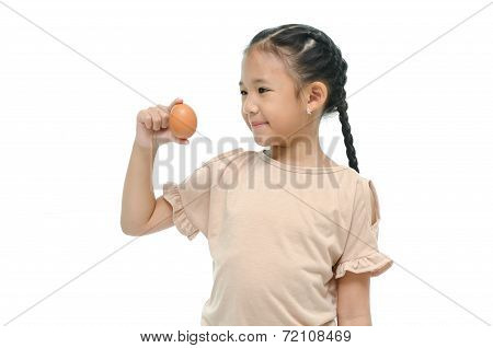 Little asian girl smiiing and holding egg