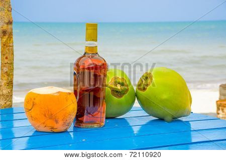 coconuts and liquor bottle on table by the beach in livingston guatemala