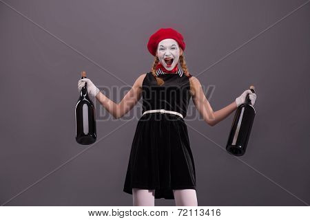 Portrait of young mime girl holding big bottles in her hands iso