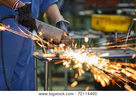 Worker Grinding Steel By Electric Grinding Machine