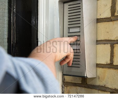Man Ringing An Intercom To Gain Access