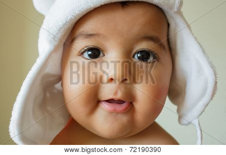 Portrait of cute happy 4 month old baby boy with funny white hat