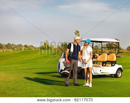Young Sportive Couple Playing Golf On A Golf Course