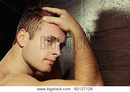 Handsome young man taking a shower
