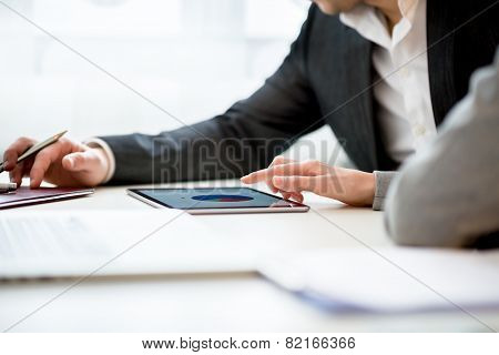 Businesspeople Discussing Business Using Tablet