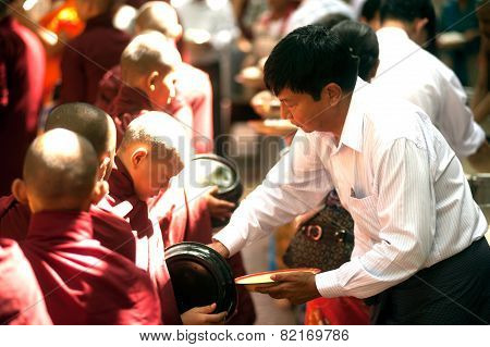 Peoples Giving With  Alms To A Buddhist Monk In Myanmar.