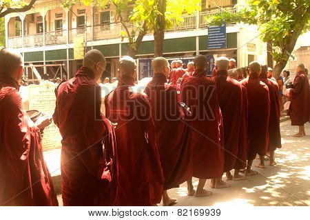 Row Of Buddhist Monks Waiting Lunch In Myanmar.