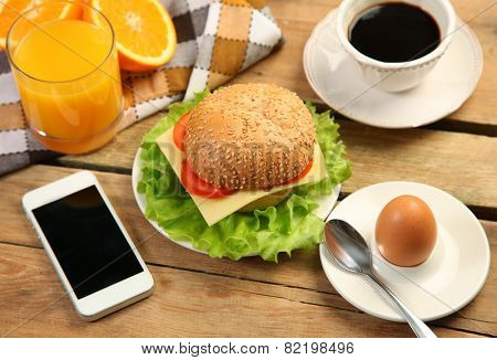 breakfast and moile phone on wooden table