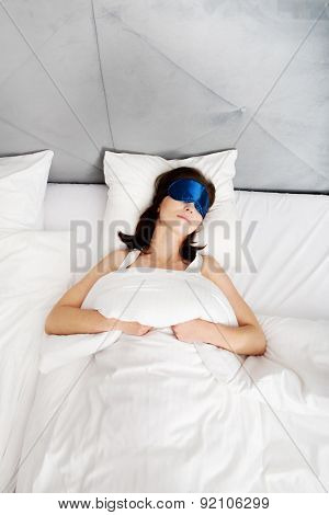 Beautiful woman sleeping in bed with eyes band.