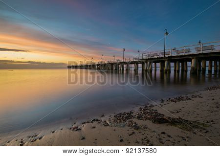 The wooden pier on the sea at sunrise