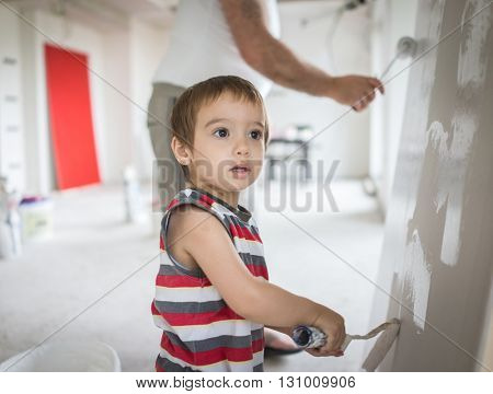 Little cute boy painting on a wall