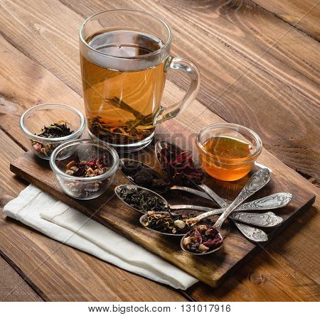 Tea composition with old spoon on wooden table