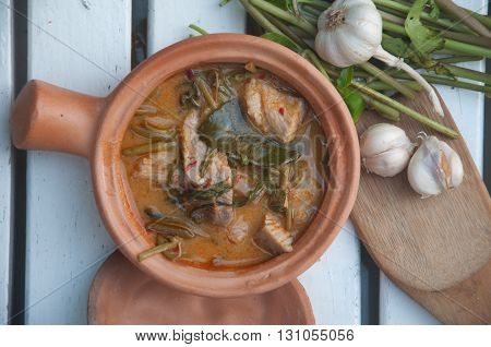 Morning glory in sour red curry Traditional Thai curry in clay bowl