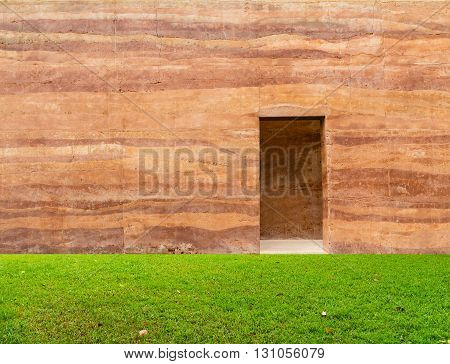 stone wall with door and grass floor in front off