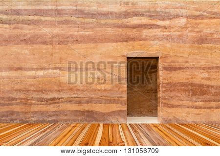 stone wall with door and wood floor in front off