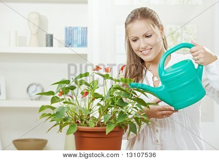 Happy young Woman Bewässerung Anlage mit Beregnung kann lächelnd.